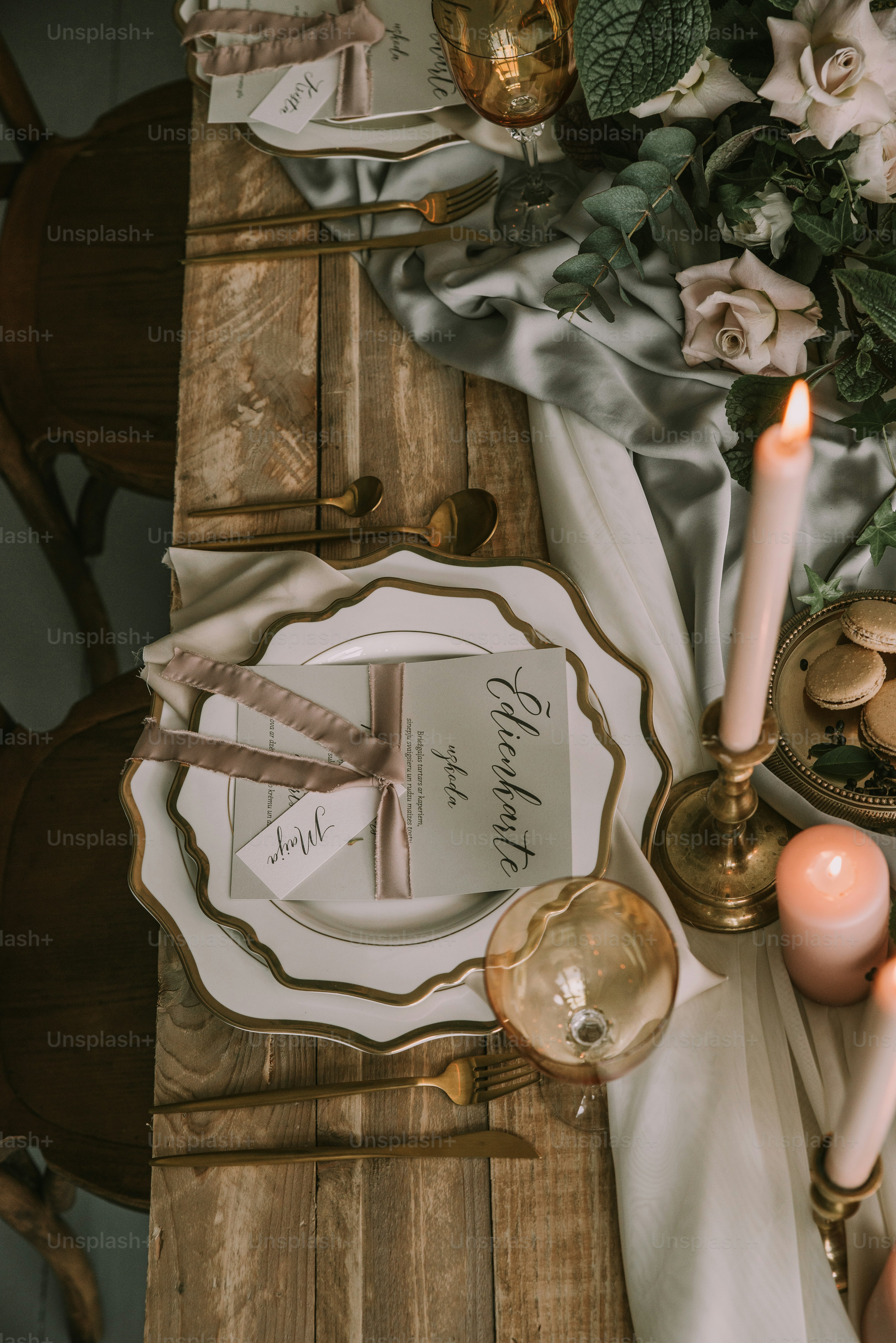 una tavola apparecchiata per una cena formale con fiori e candele