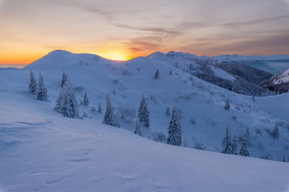 夕日を背景に雪に覆われた山