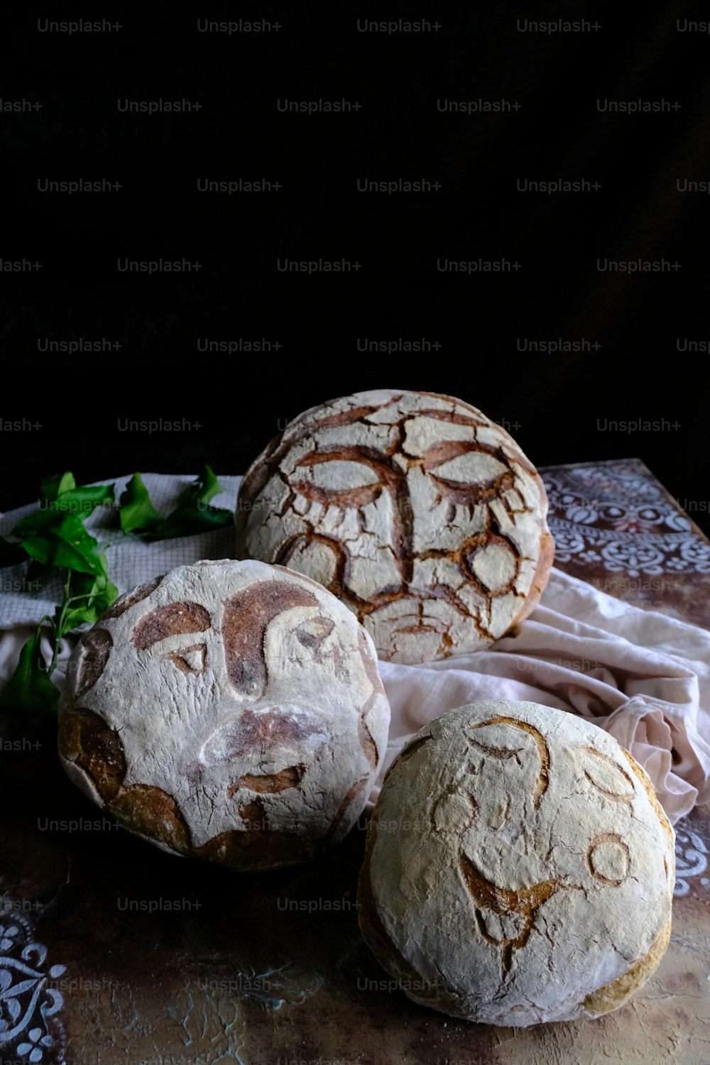 테이블 위에 앉아있는 세 개의 둥근 빵