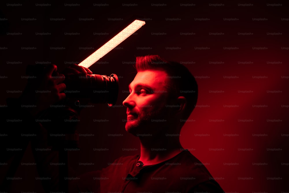 a man holding a camera and a light saber