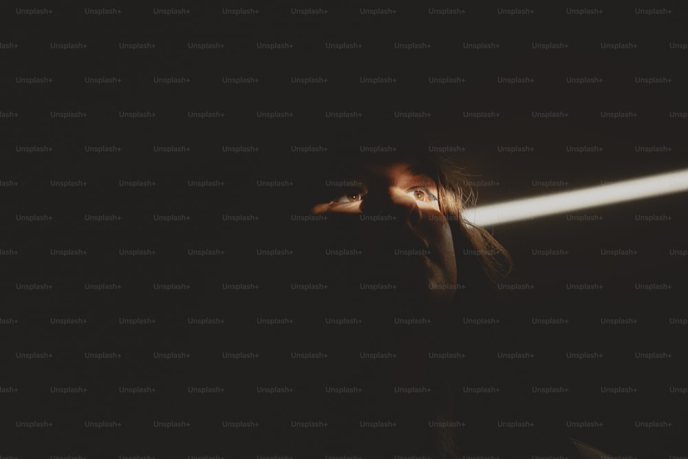 Una mujer sosteniendo una linterna en la oscuridad