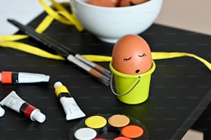 una mesa cubierta con un tazón de huevos y pintura