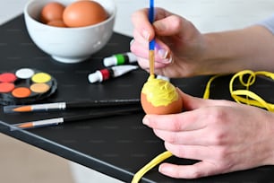 Eine Person, die ein Ei auf einen Tisch malt