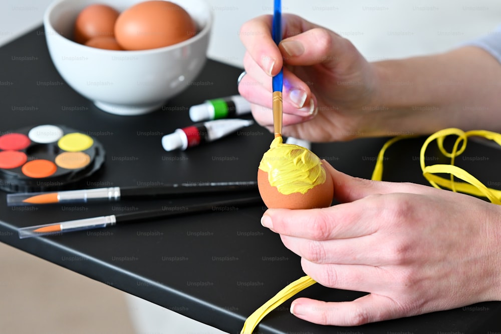 a person painting an egg on a table