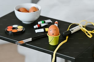 ein Tisch mit einer Schüssel mit Eiern und Markern
