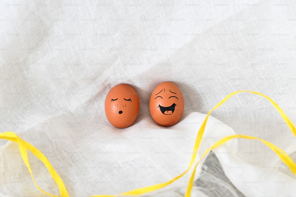 two orange eggs with faces painted on them
