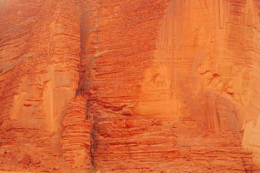 a man riding a horse in front of a large rock formation