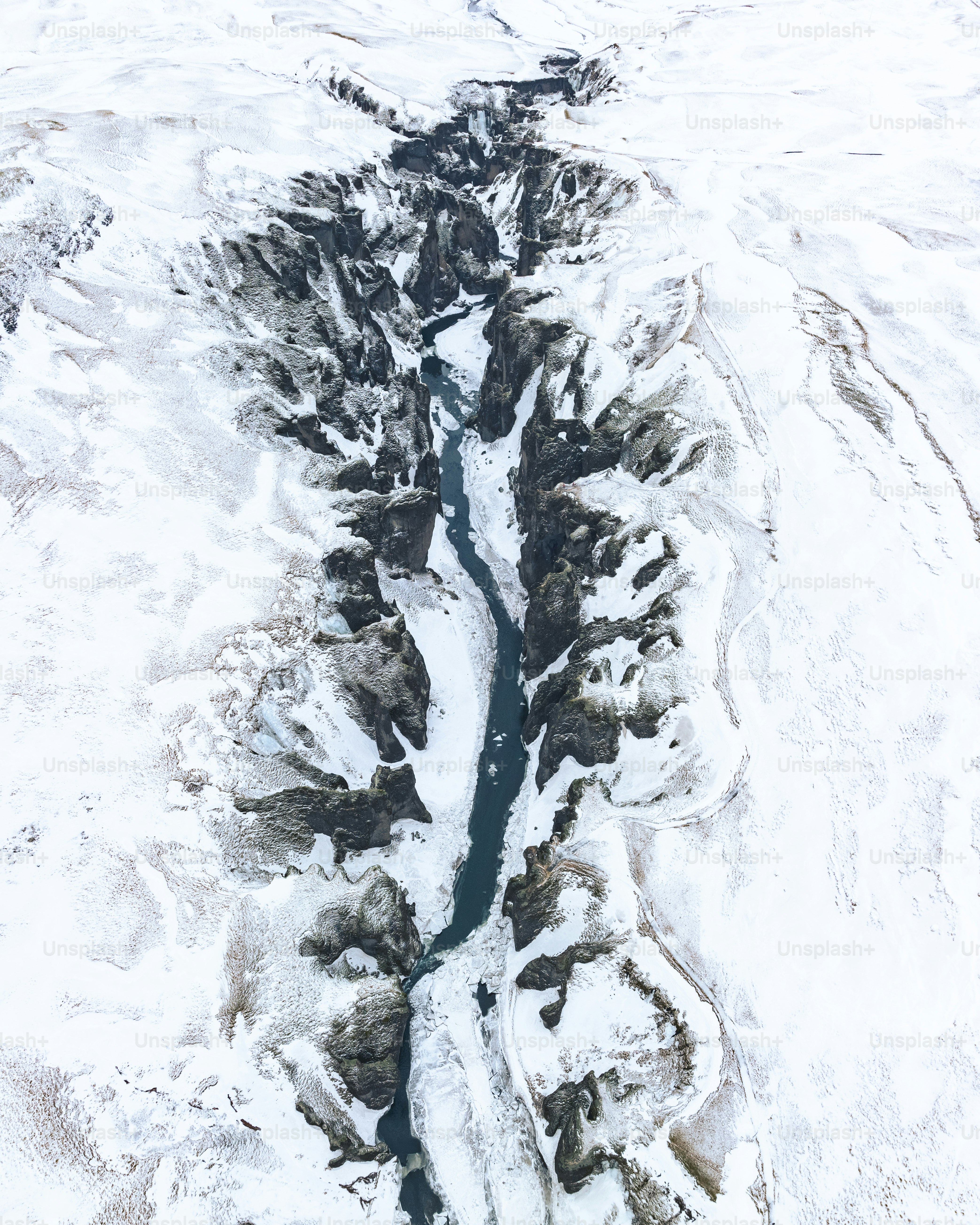 an aerial view of a river running through a snow covered landscape