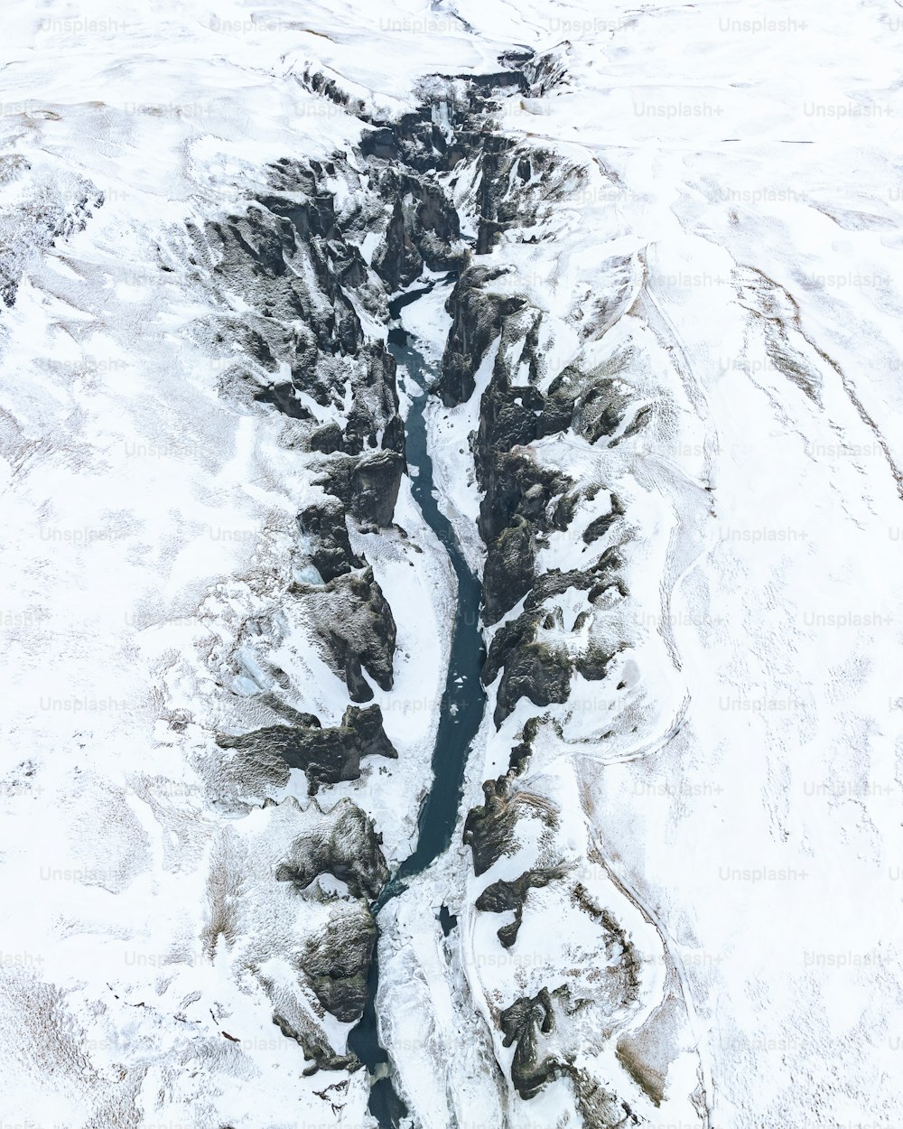 雪景色の中を流れる川の空撮