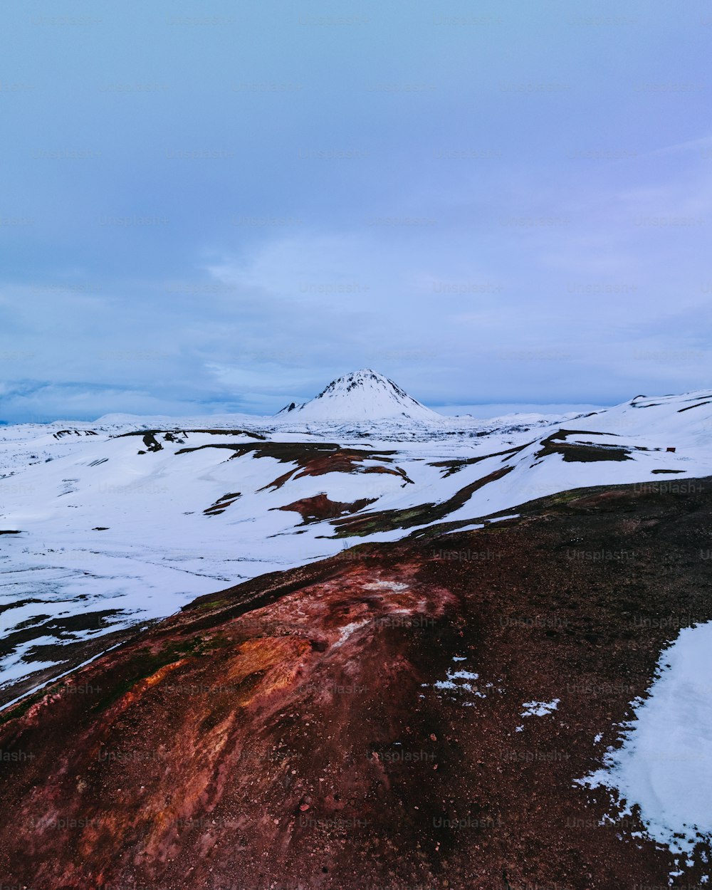 a mountain covered in snow with a sky background