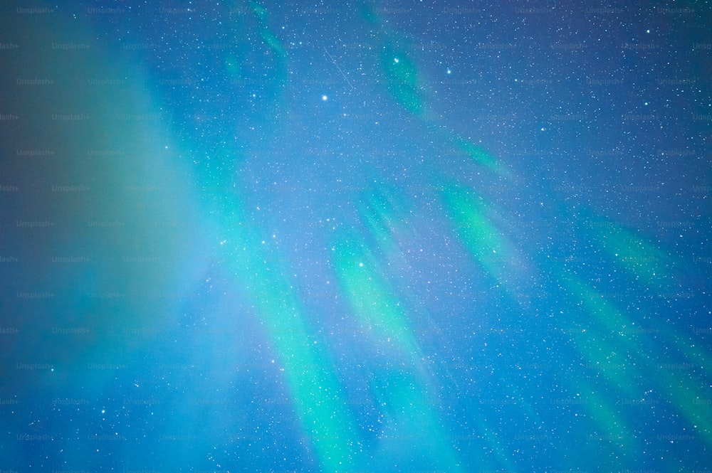 Un cielo verde y azul brillante lleno de estrellas