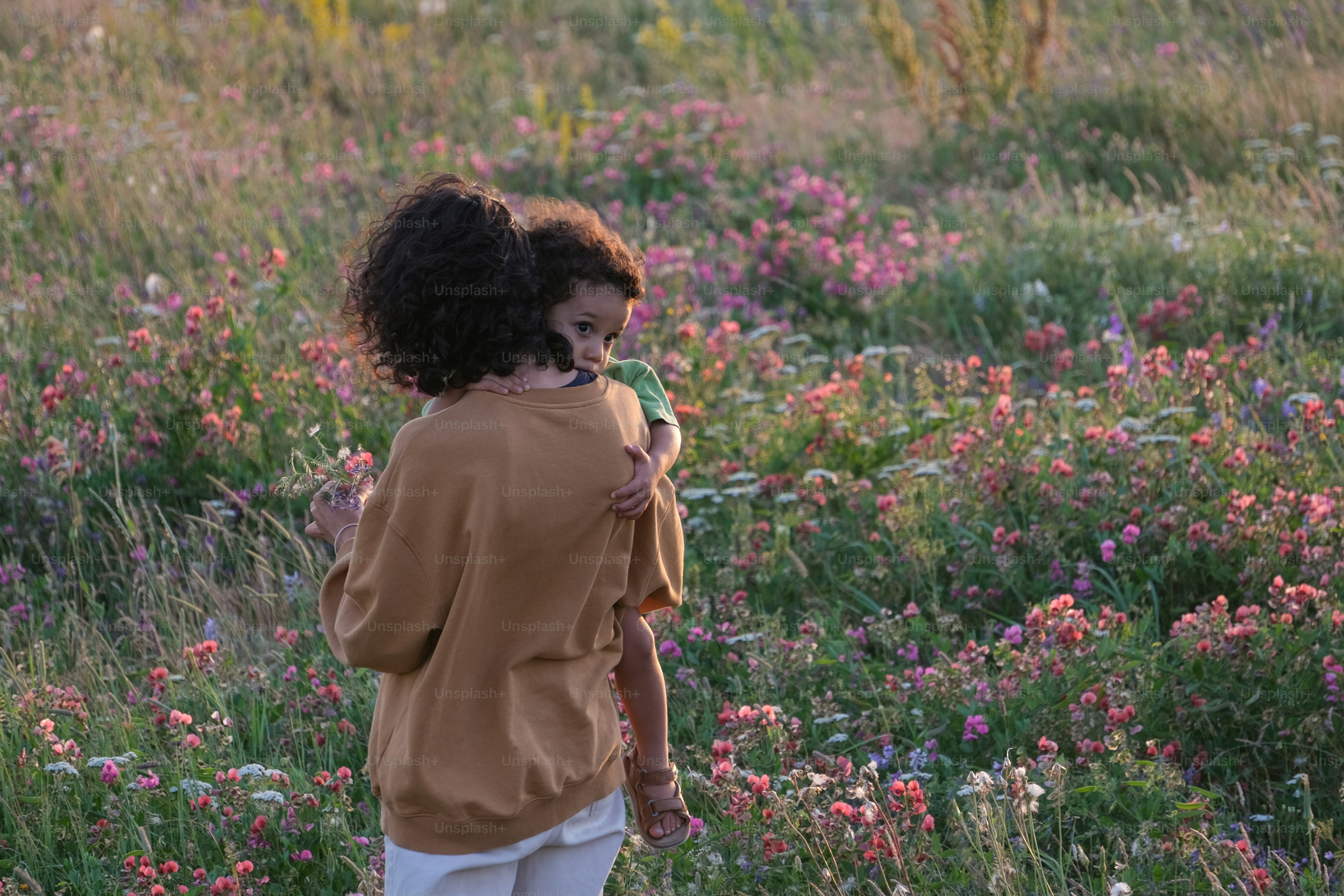 a little girl standing in a field of flowers