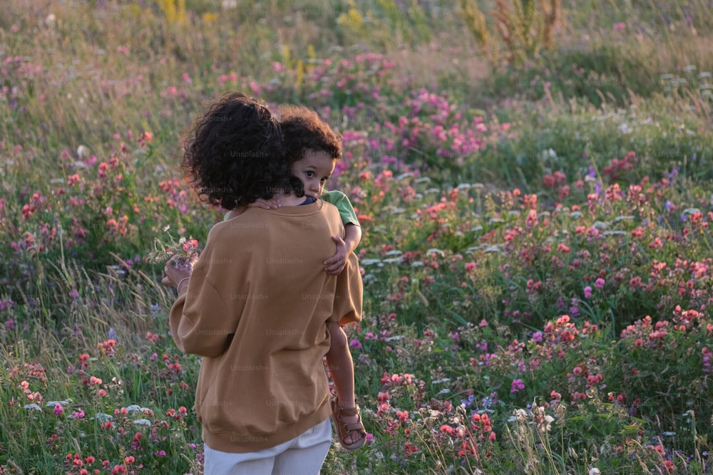 Ein kleines Mädchen steht in einem Blumenfeld