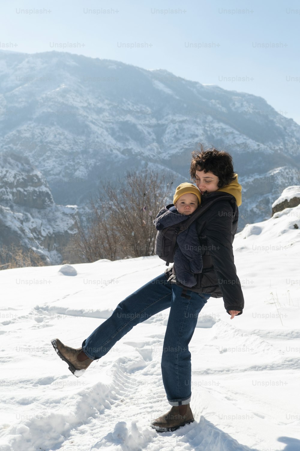 Eine Frau, die ein Kind im Schnee hält