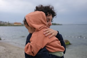 a woman holding a child on the beach