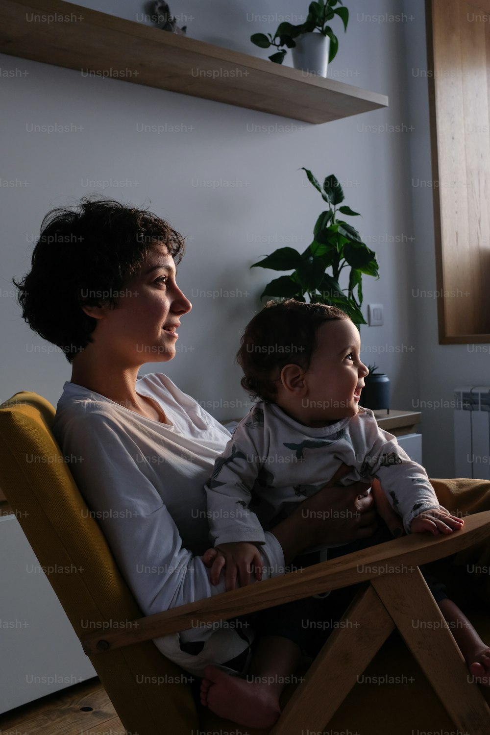 赤ん坊を抱えた椅子に座っている女性
