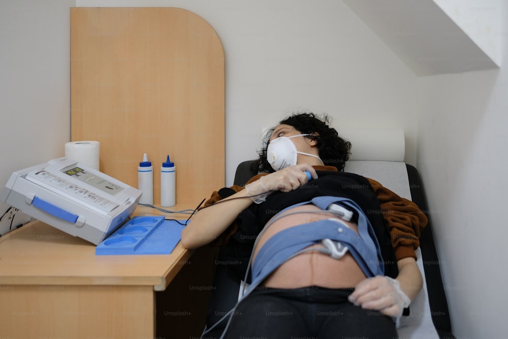 Eine Frau liegt auf einem Bett mit einem Beatmungsgerät im Mund