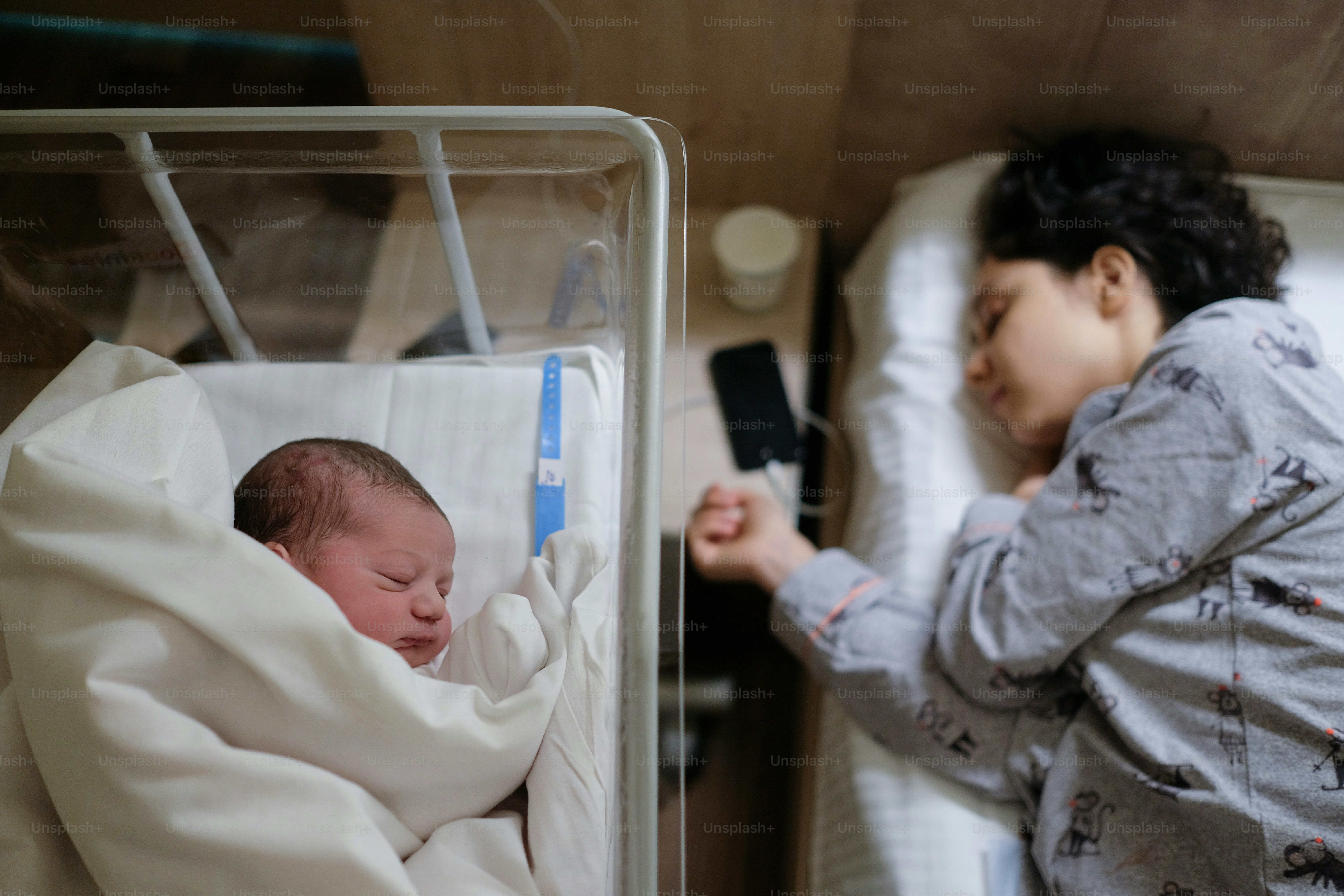 Ein Baby in einer Krippe mit einem Thermometer daneben