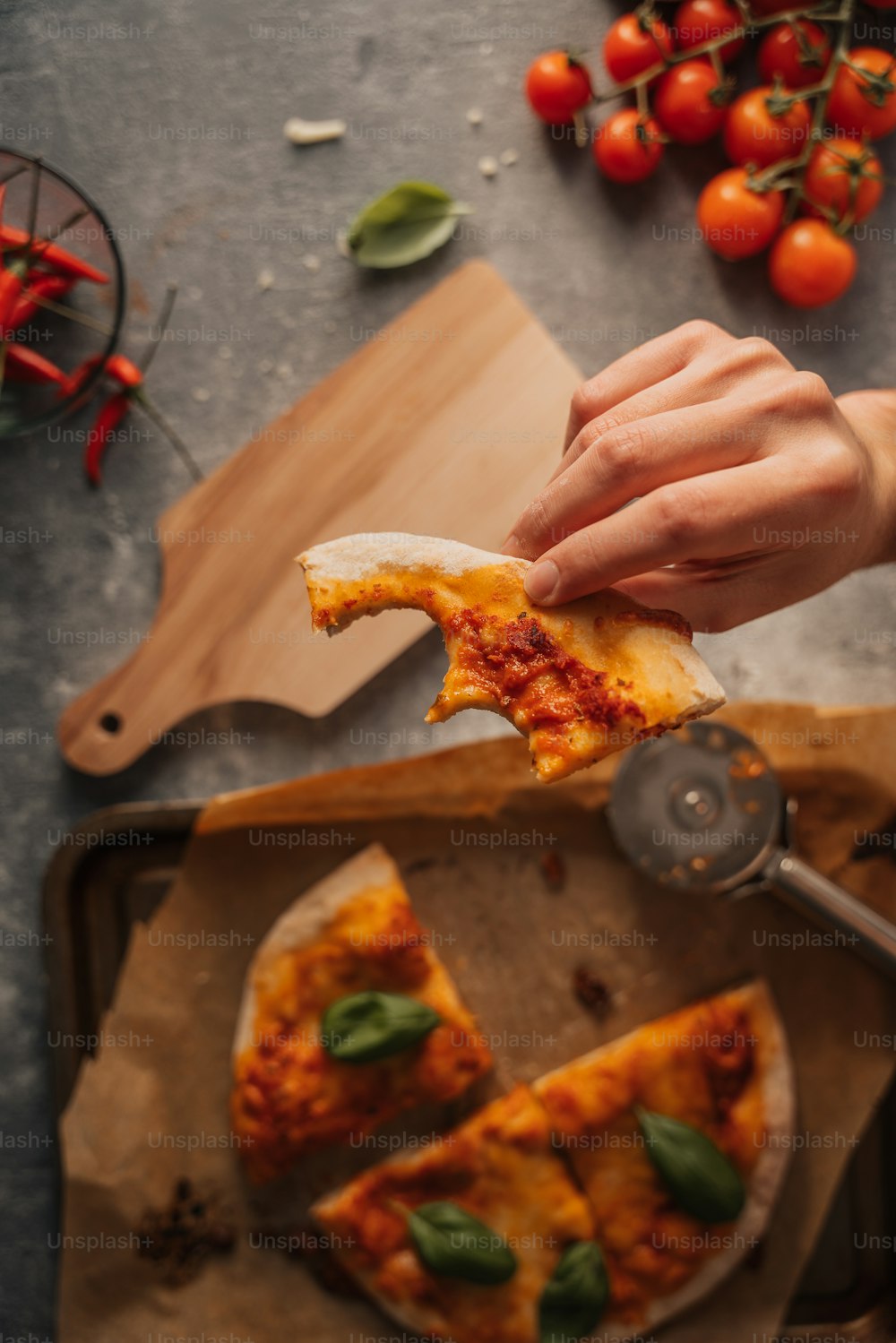 a person taking a slice of pizza from a pan