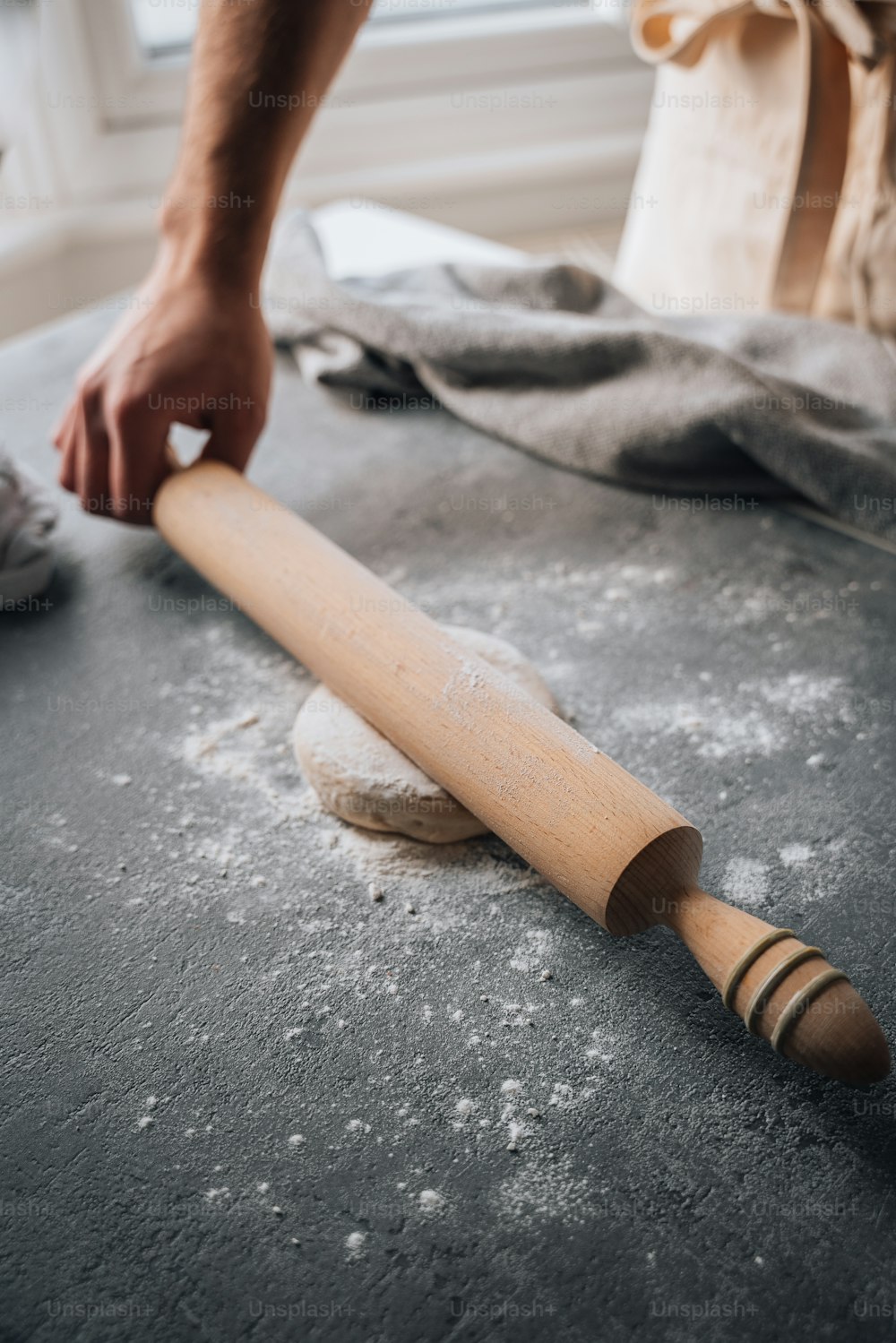 a person rolling dough on a table with a rolling pin