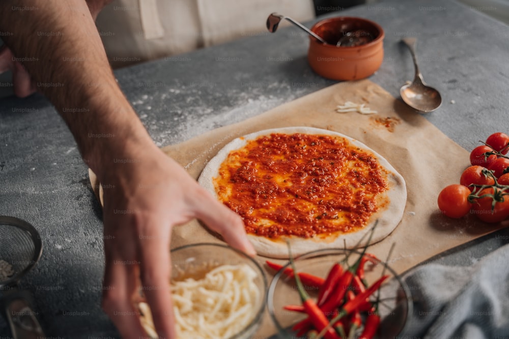 a person making a pizza on top of a table