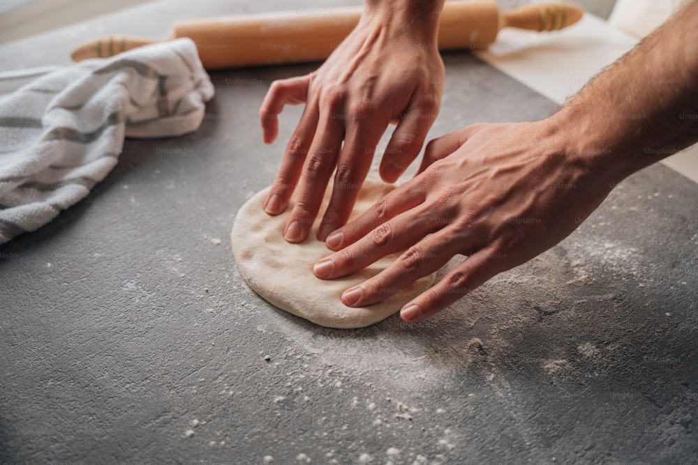 a person is kneading dough on a table