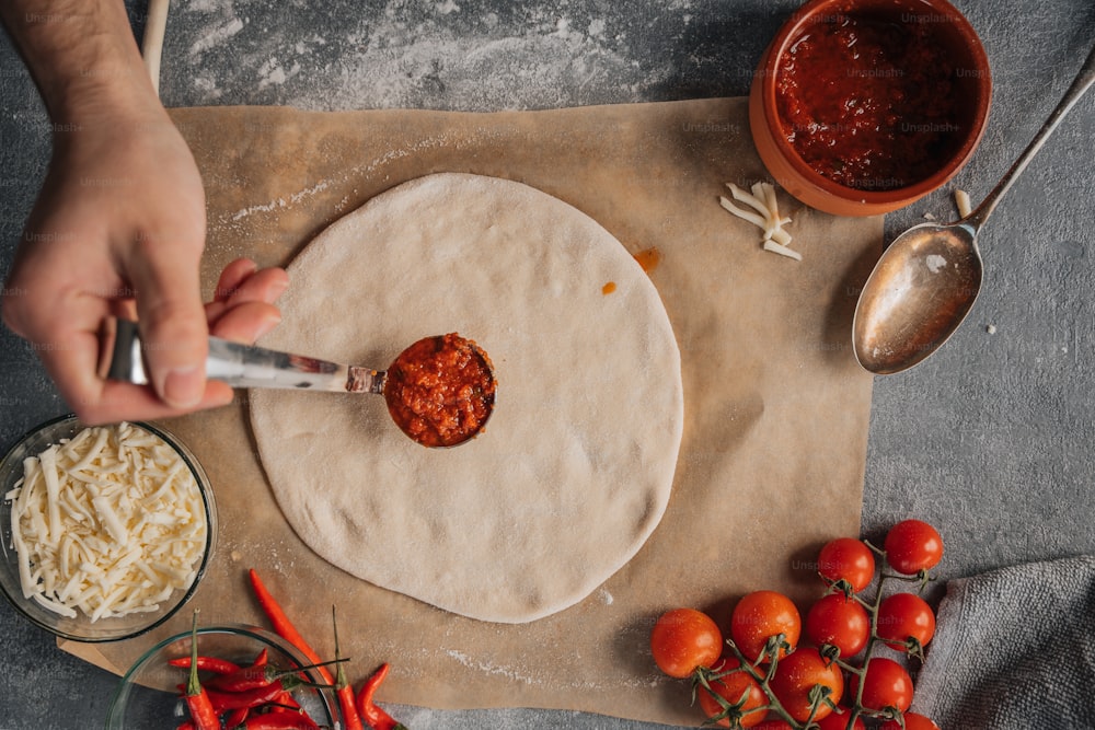 a person using a knife to spread cheese on a tortilla