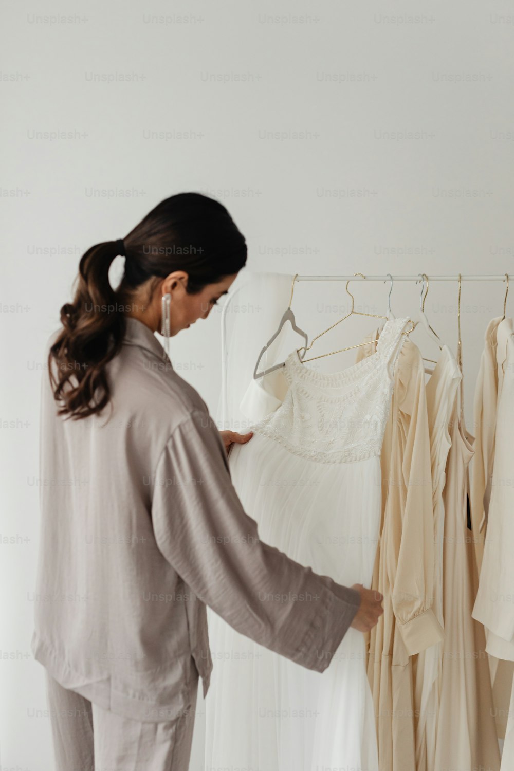 uma mulher olhando para um vestido em um rack