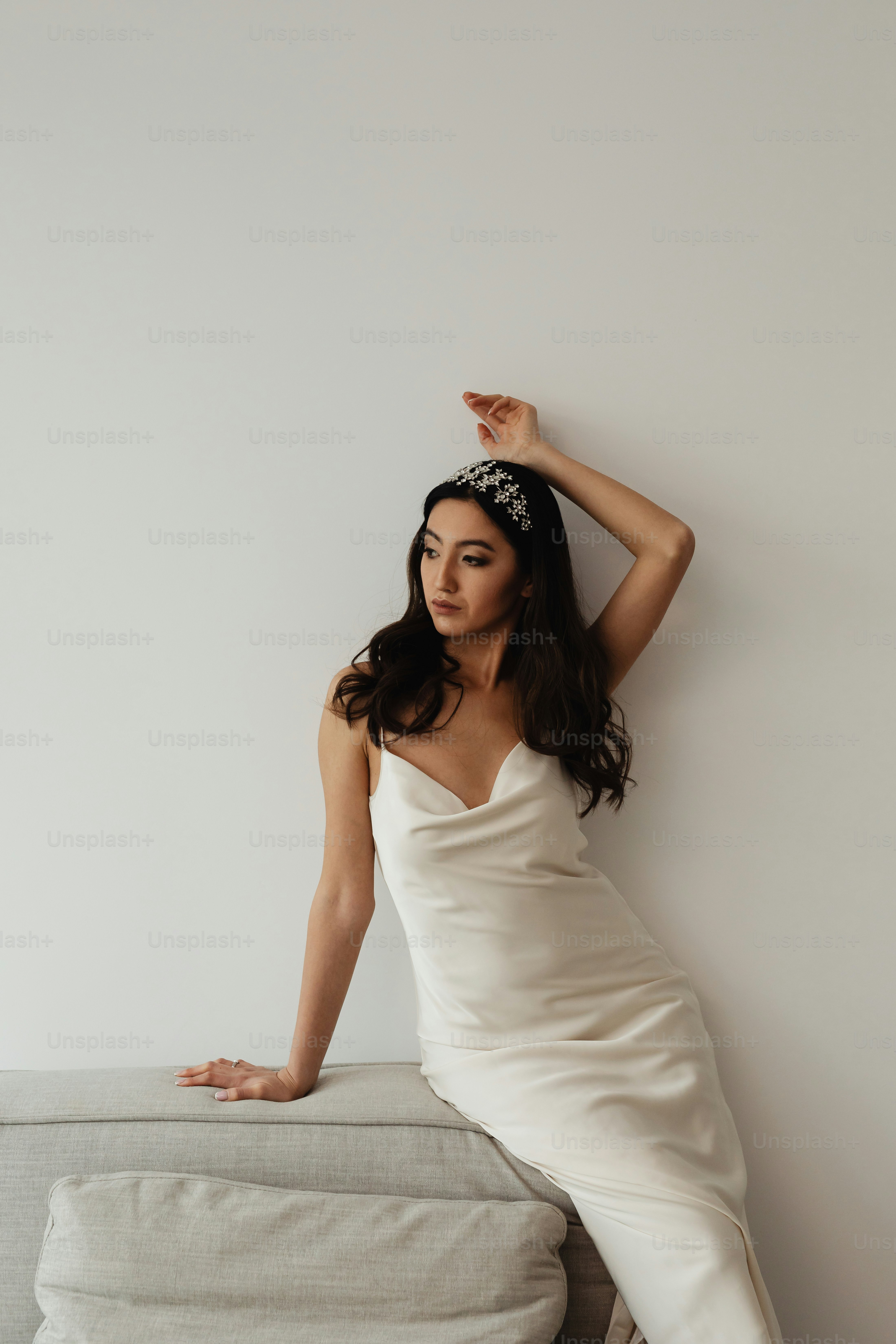 Una mujer con un vestido blanco sentada en un sofá