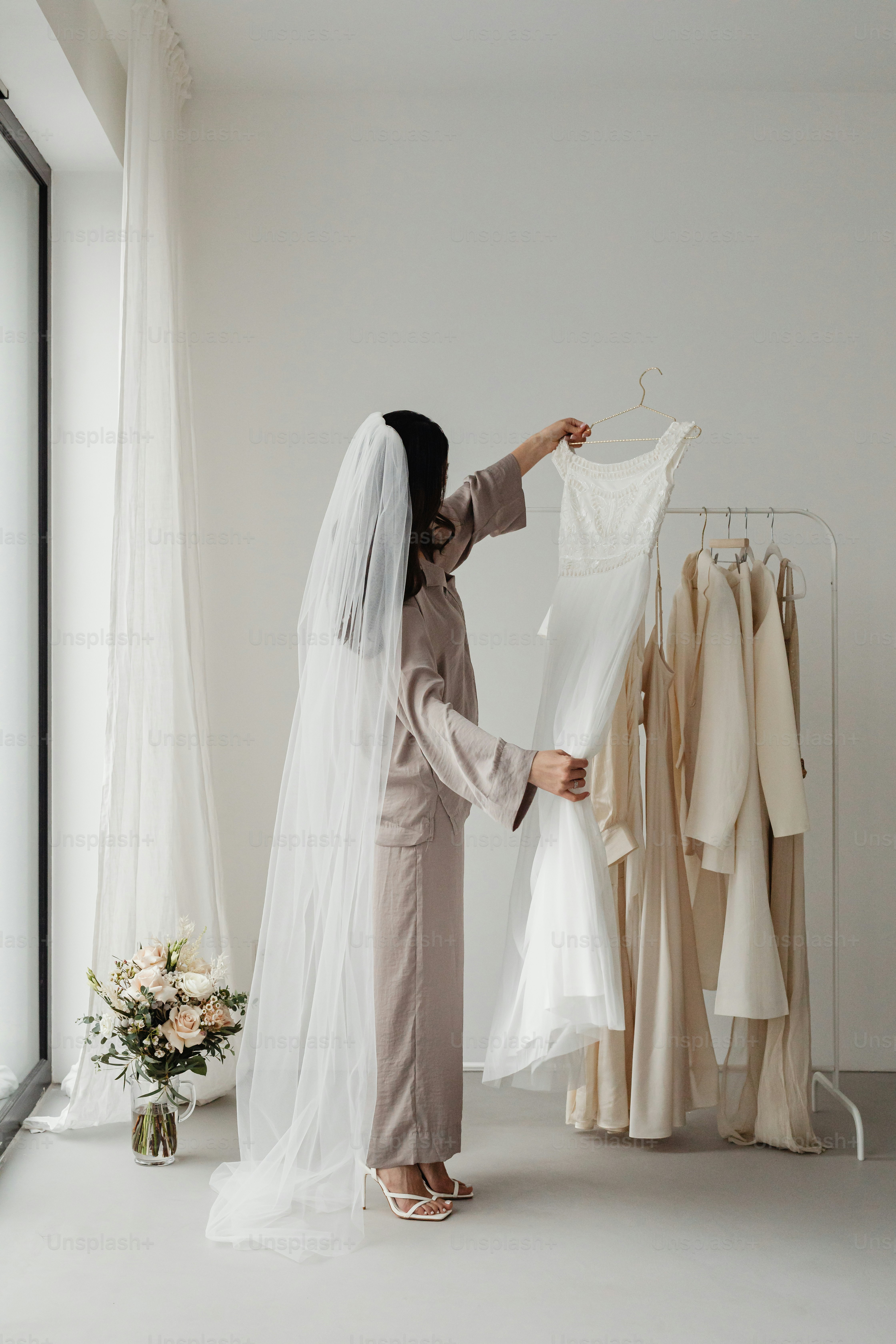 a woman in a bridal gown looking at a wedding dress