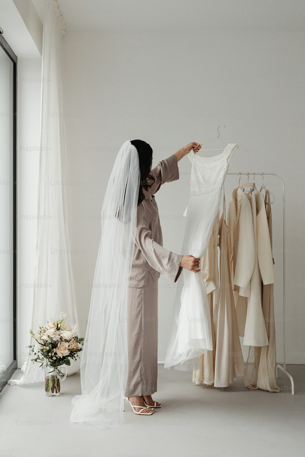 a woman in a bridal gown looking at a wedding dress