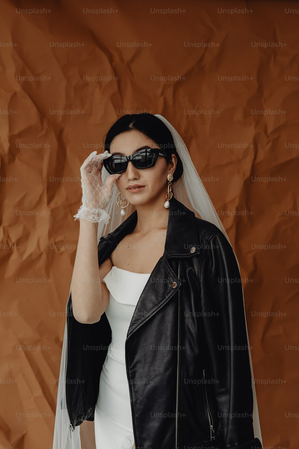 Una mujer con un vestido blanco y una chaqueta de cuero negro