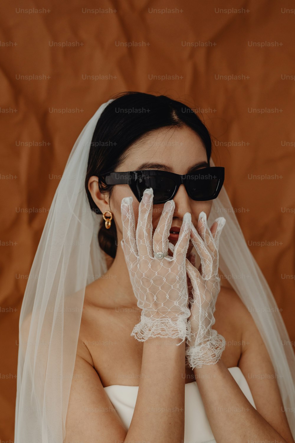a woman wearing white gloves and a veil