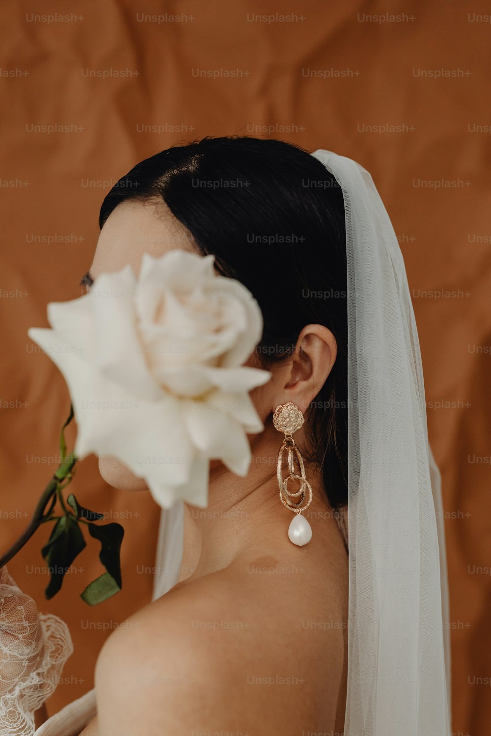 Una donna in un abito da sposa con un fiore tra i capelli