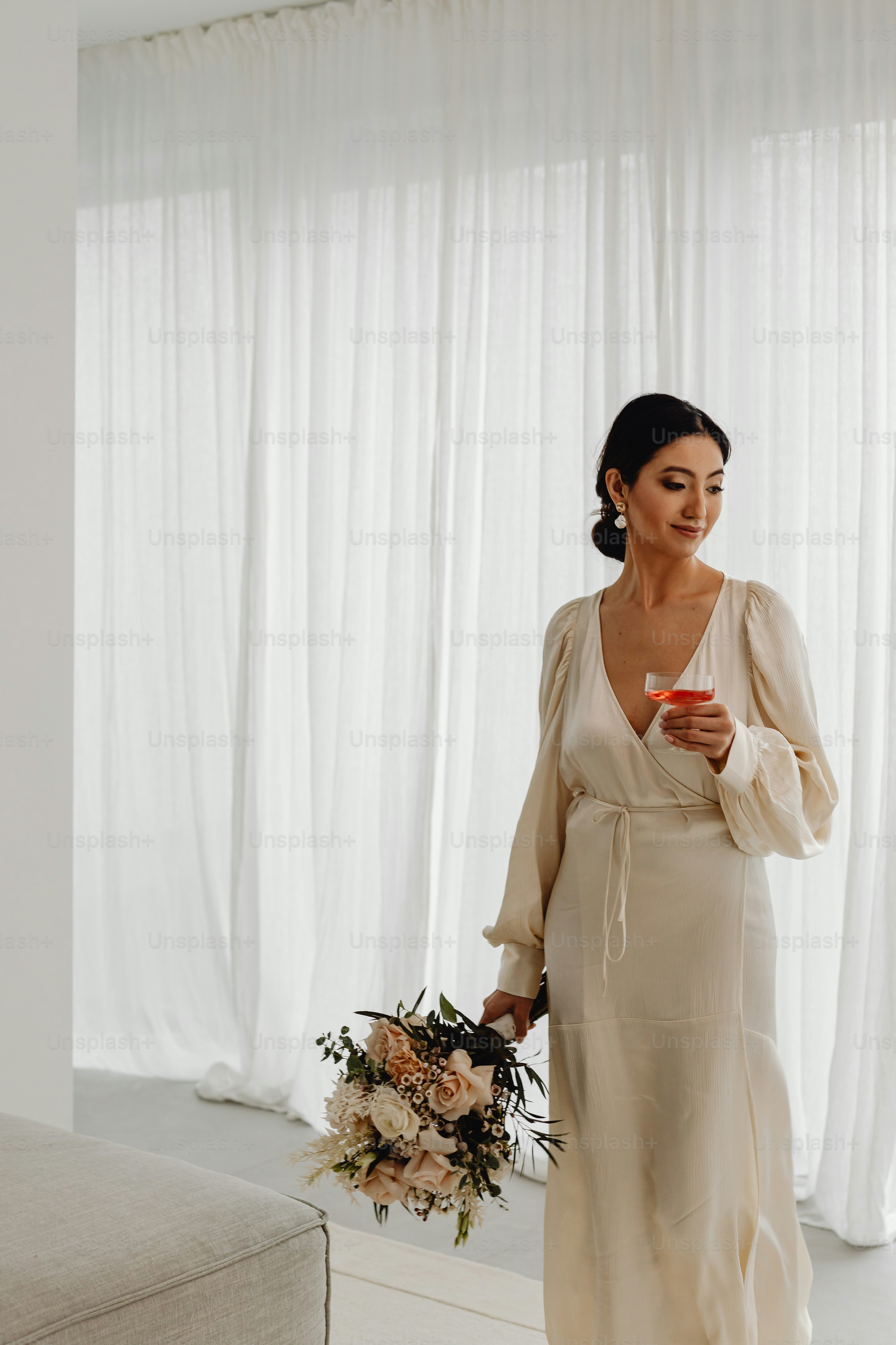 a woman standing in a room holding a bouquet of flowers