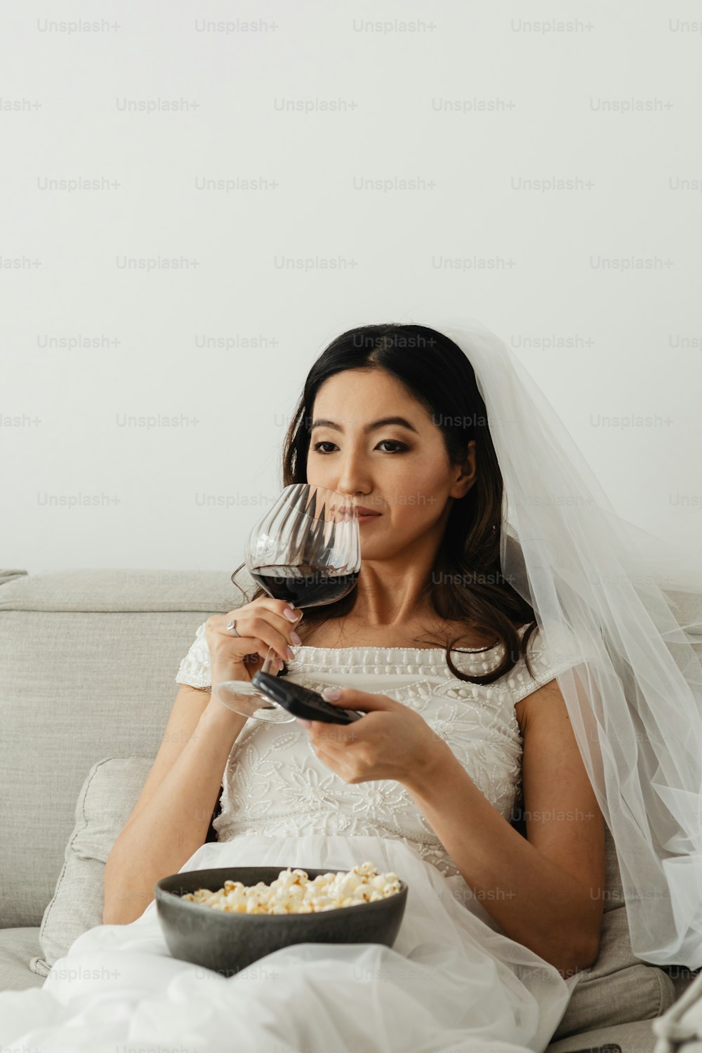 a woman sitting on a couch holding a glass of wine