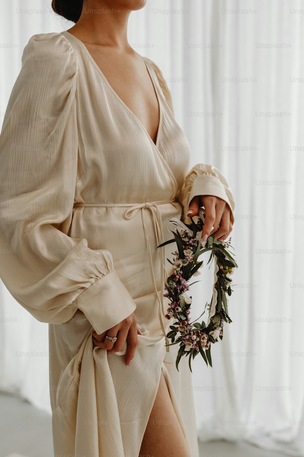 a woman in a dress holding a wreath