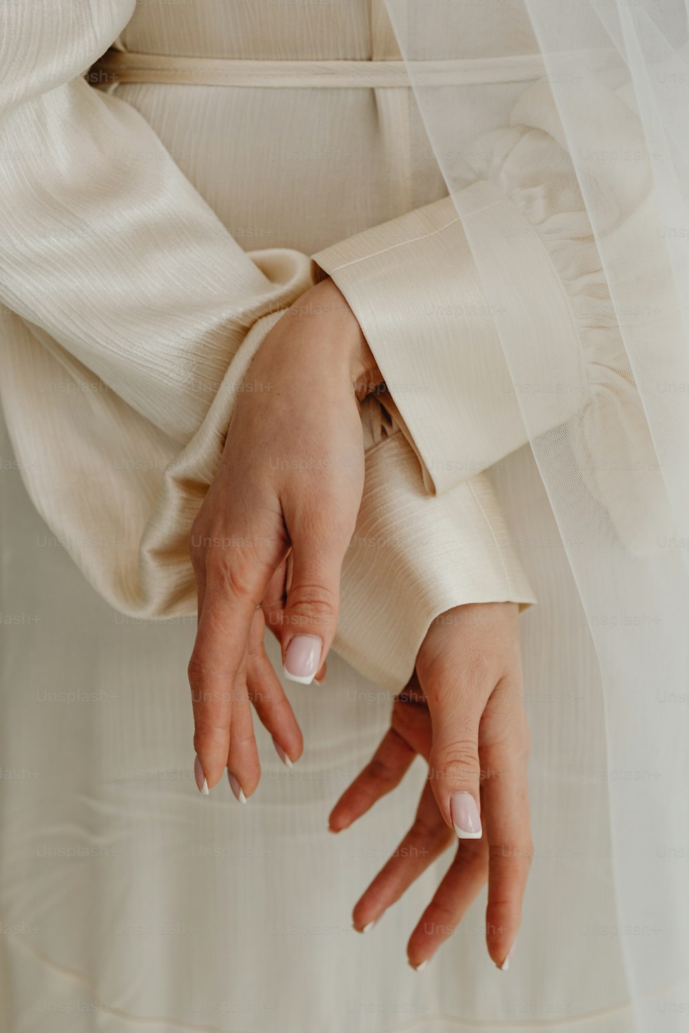 Un primer plano de las manos de una persona con un vestido de novia