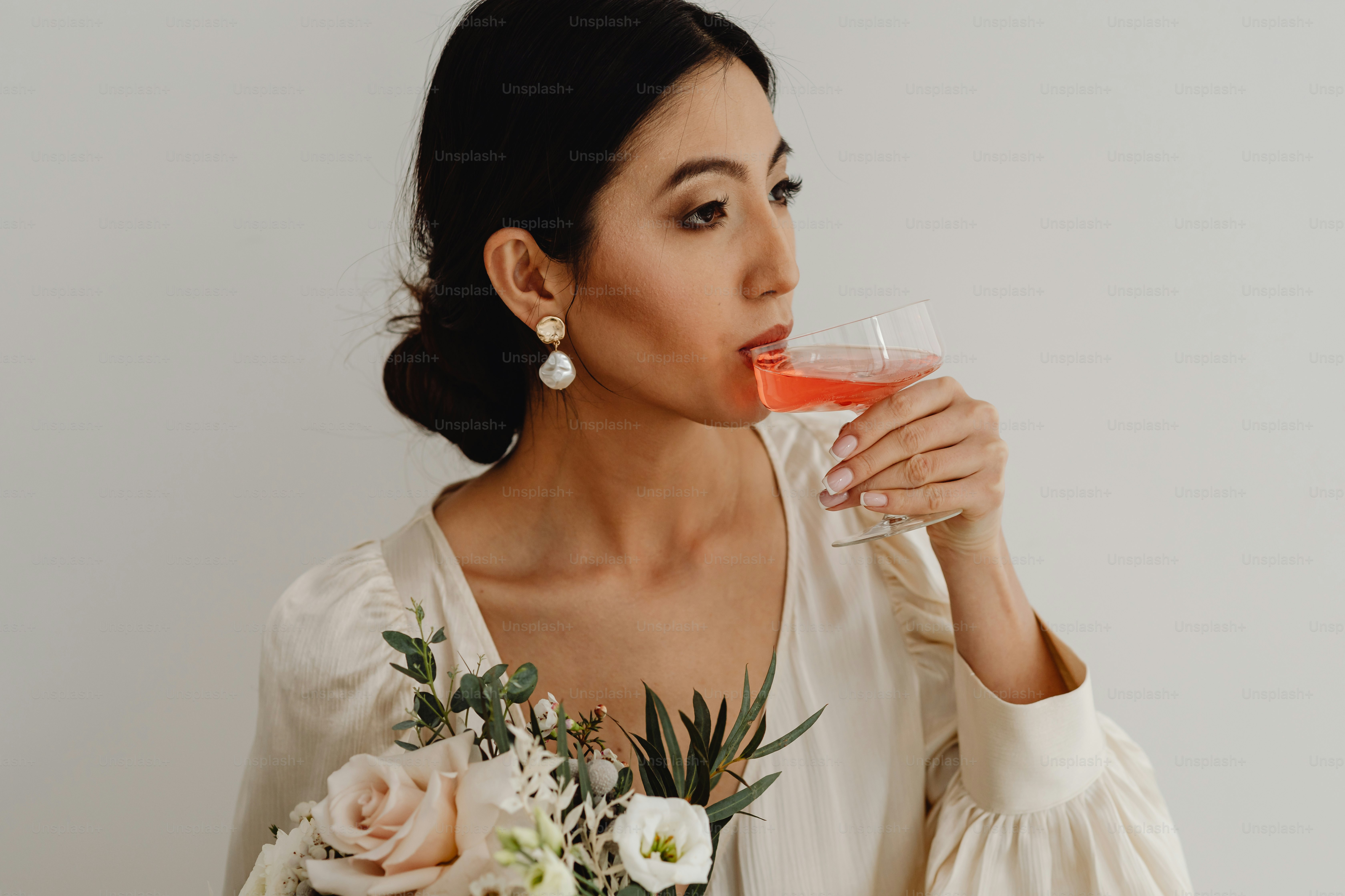 A woman in a white dress holding a glass of wine photo – Wedding ...