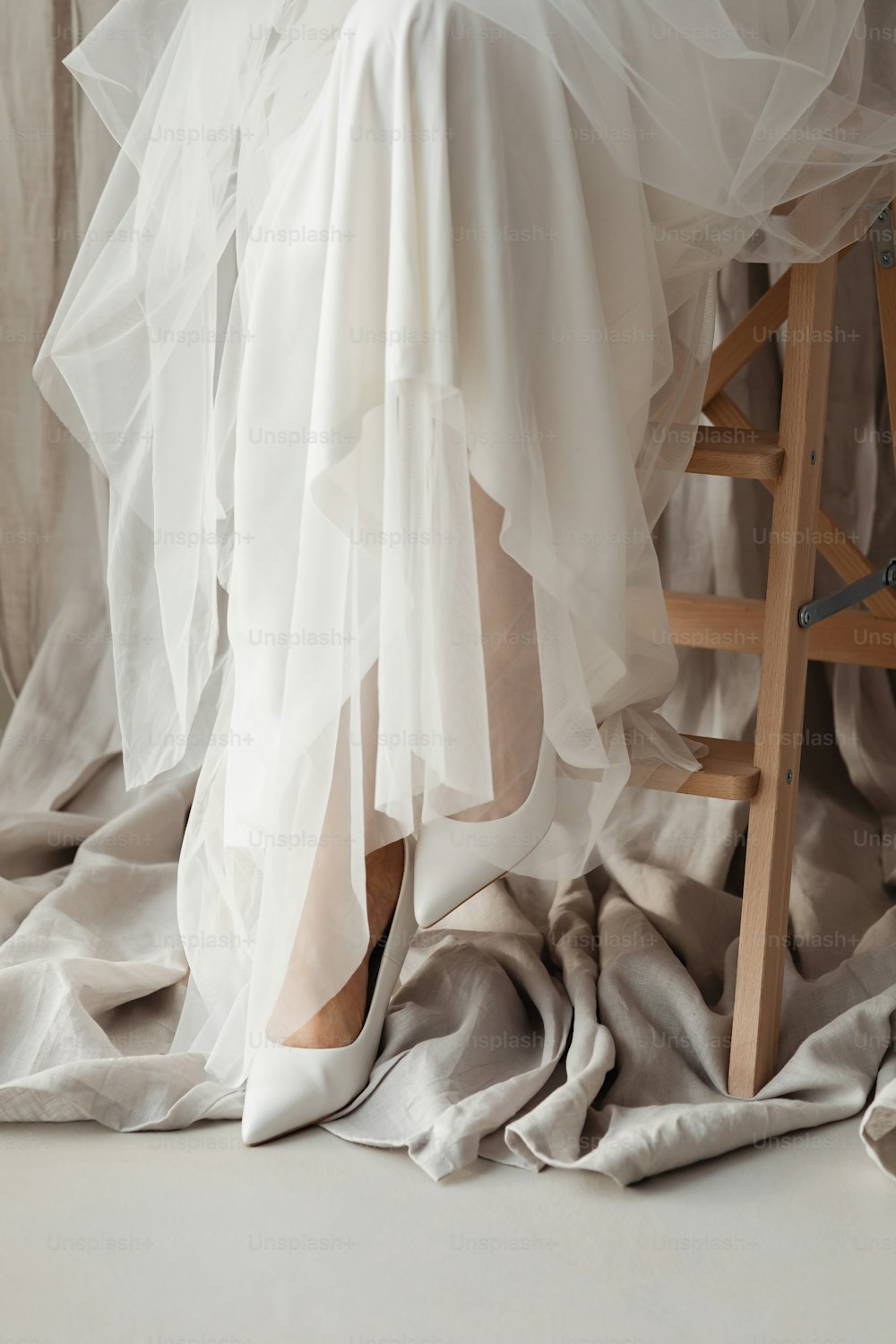 a woman in a white dress is sitting on a chair