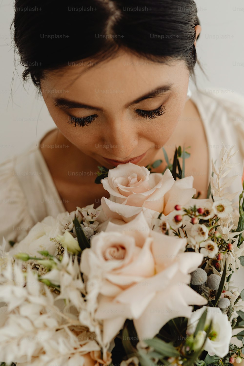a woman is smelling a bouquet of flowers