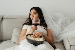 Une femme assise sur un canapé tenant un verre de vin