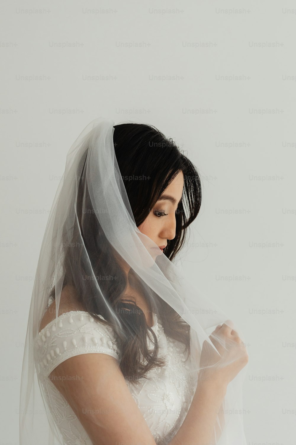 uma mulher em um vestido de noiva com um véu em sua cabeça