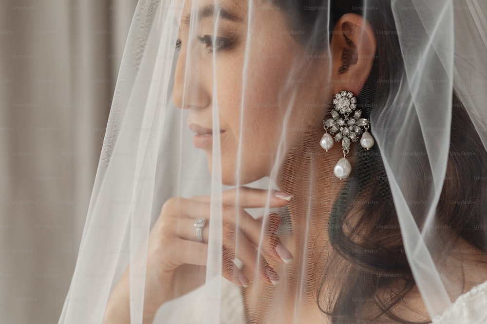 a woman wearing a veil and a pair of earrings