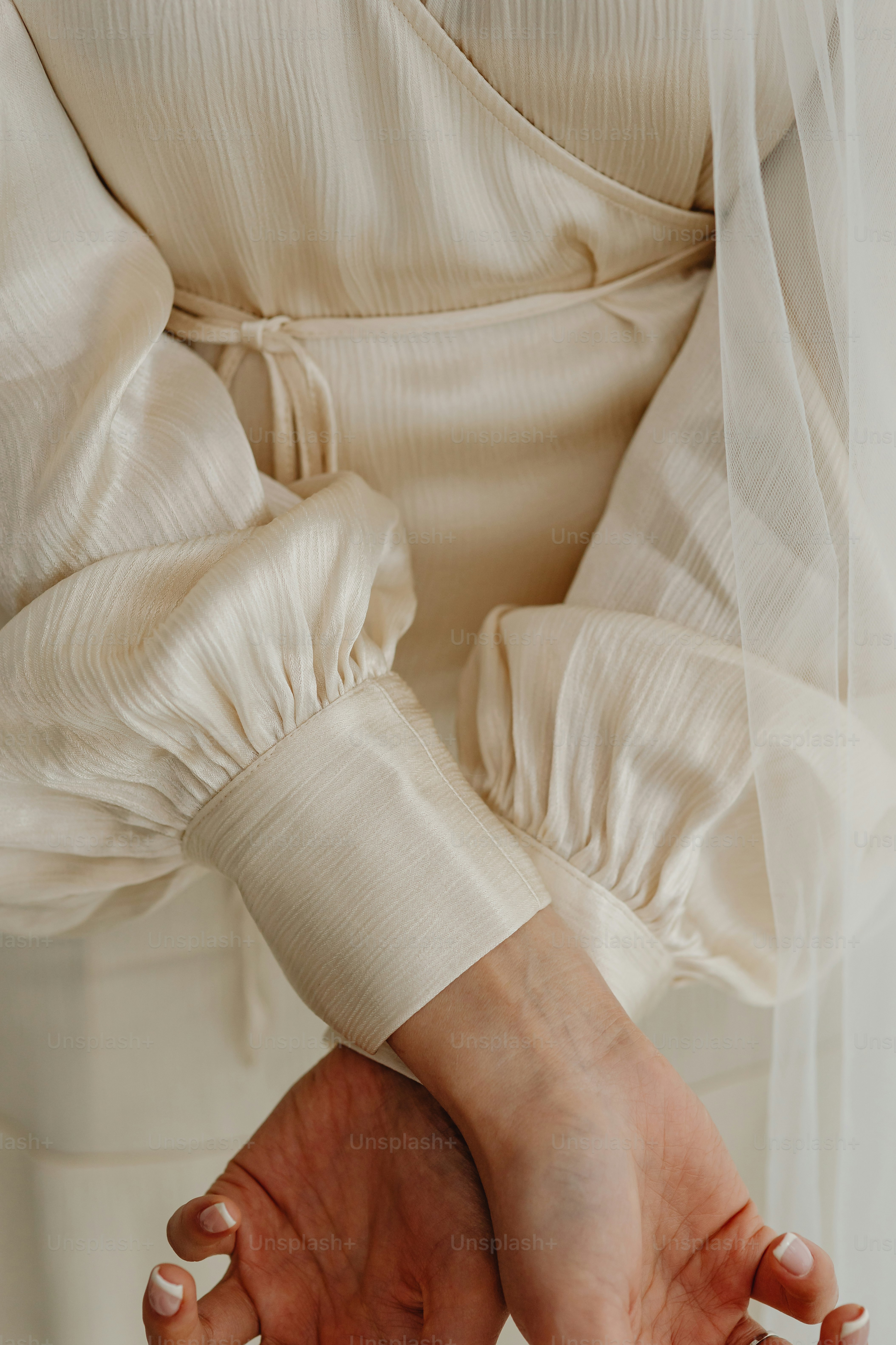 a woman in a white dress holding her hands together