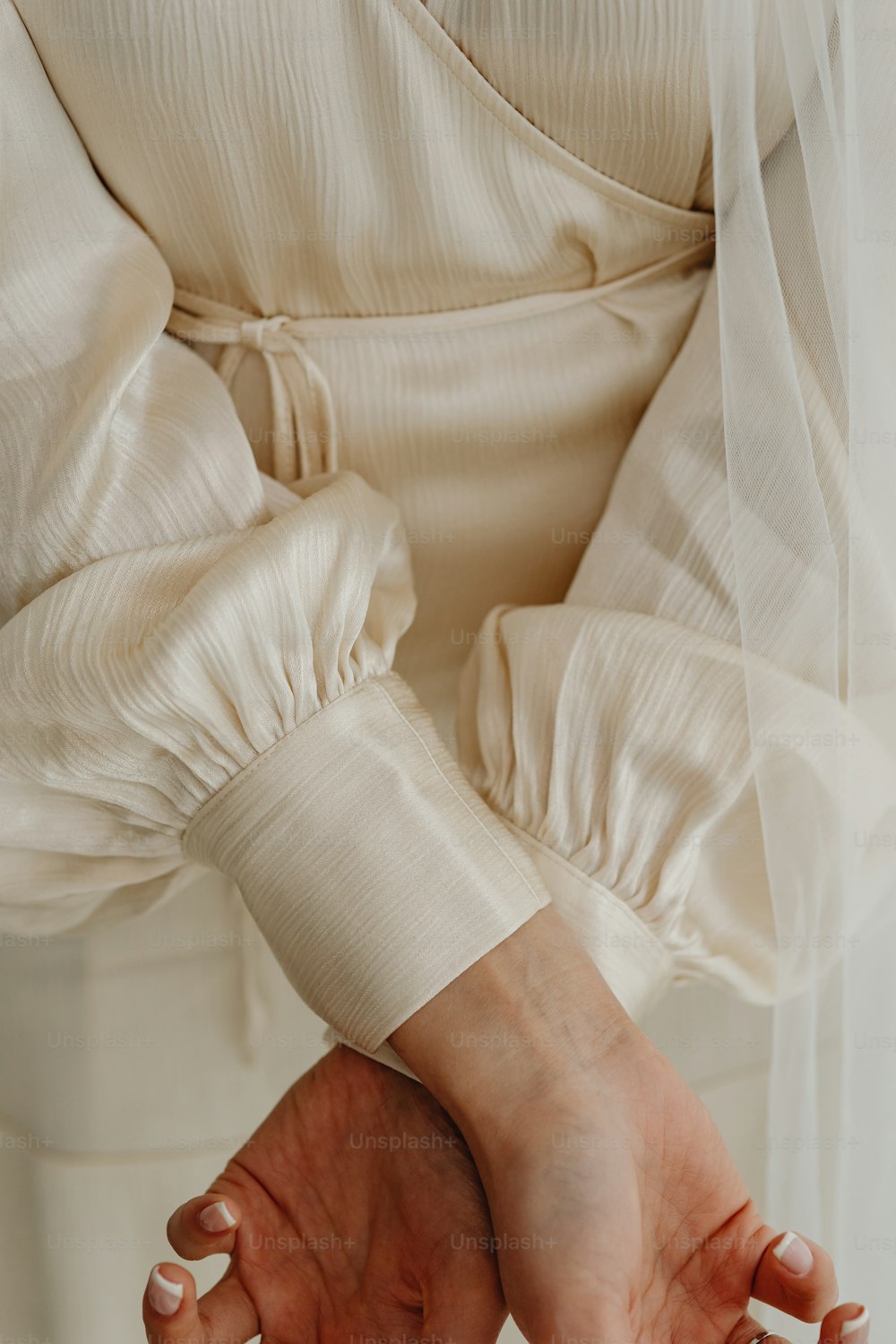 a woman in a white dress holding her hands together