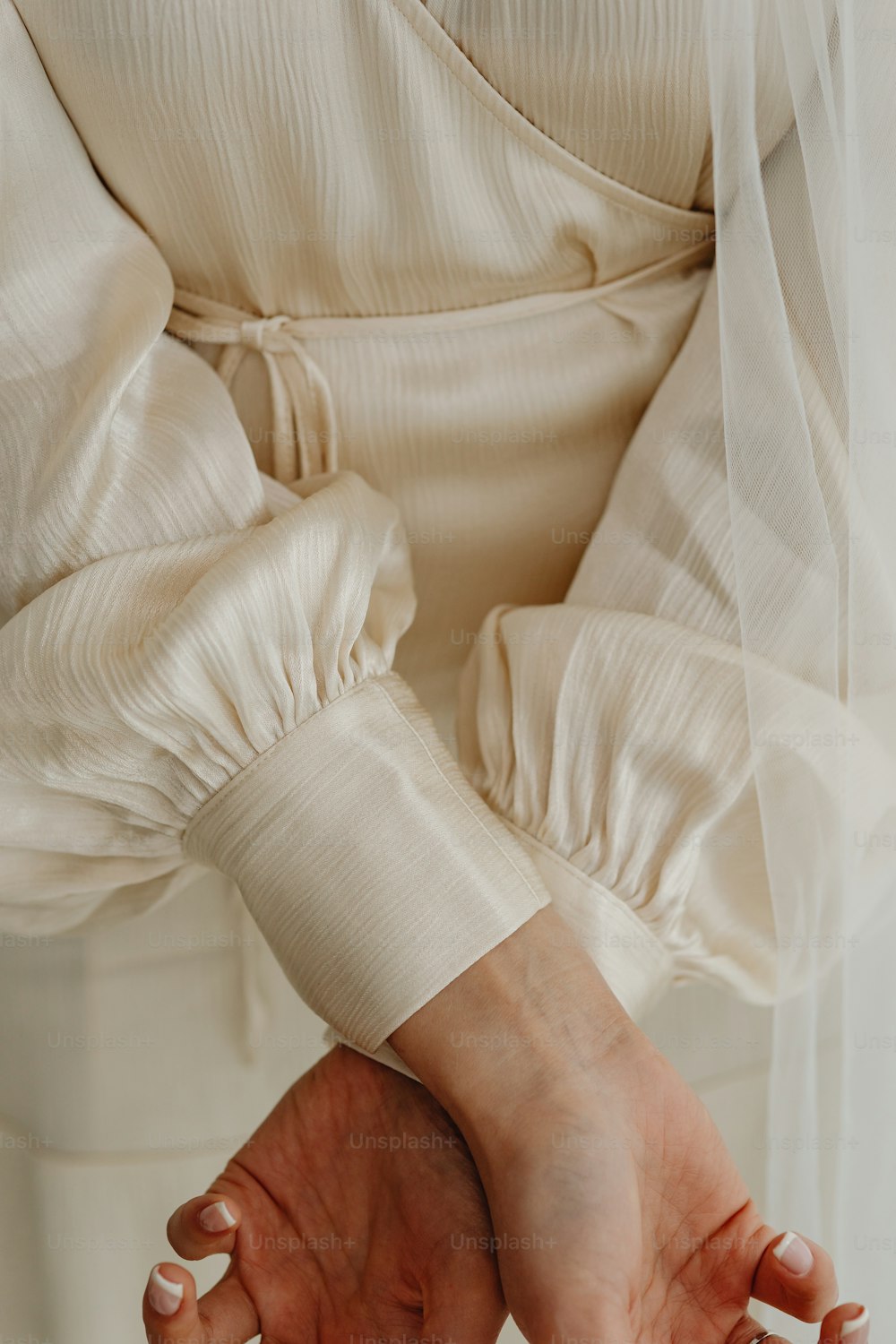 Eine Frau in einem weißen Kleid, die ihre Hände zusammenhält