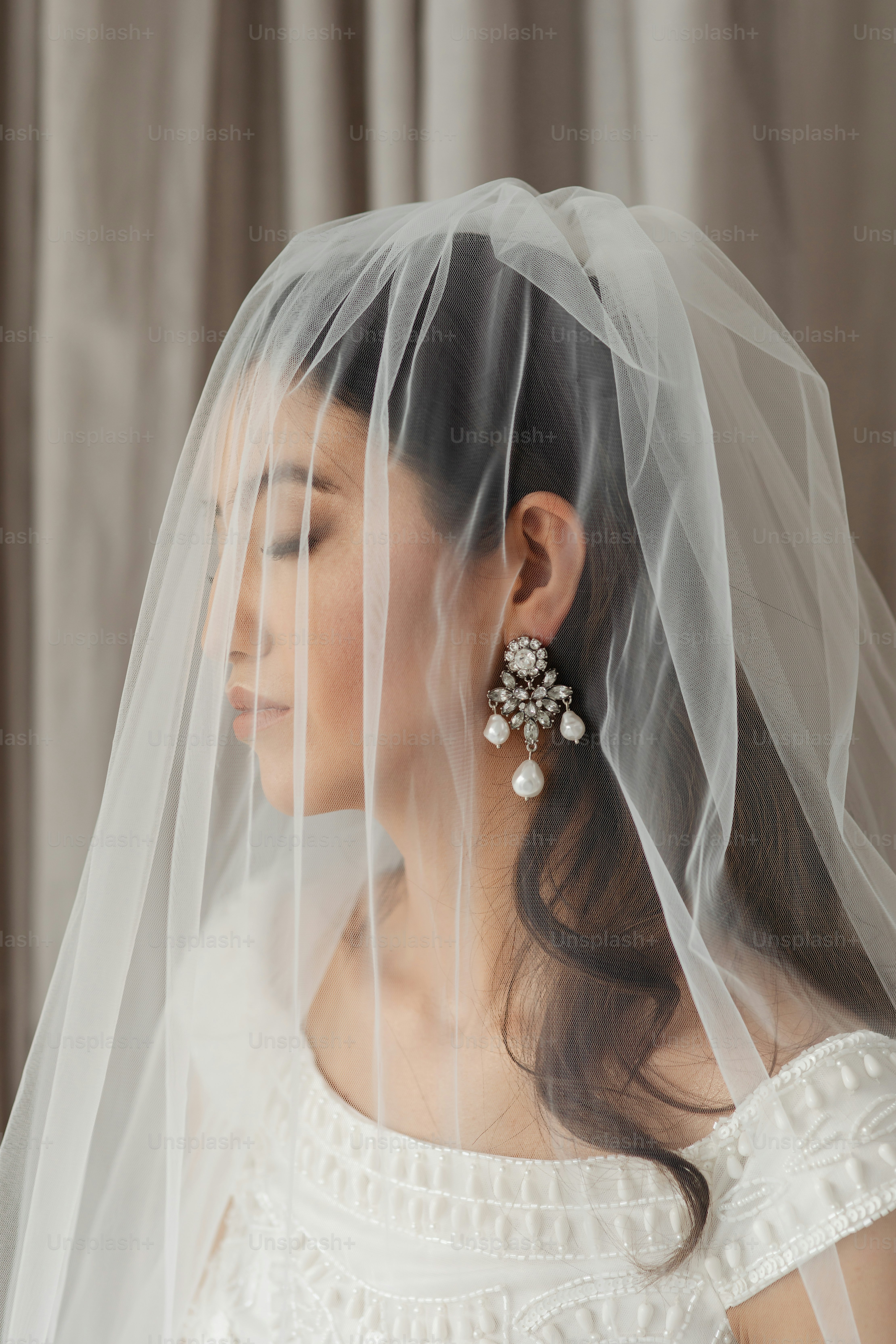 a woman wearing a veil and earrings