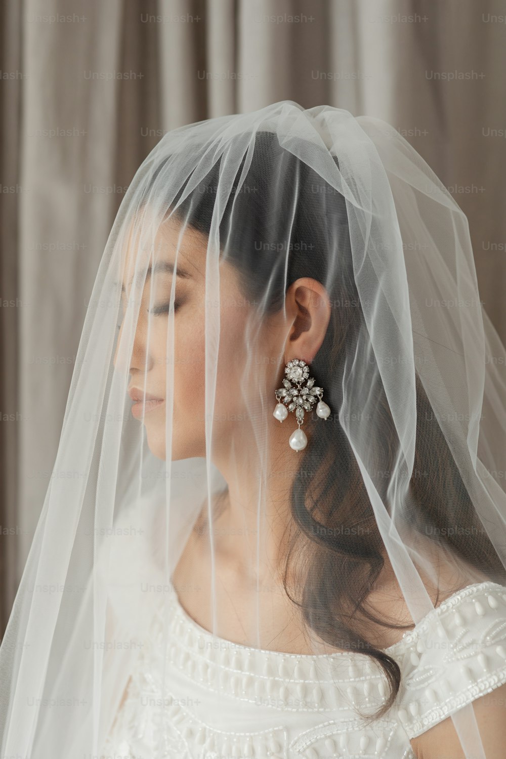 a woman wearing a veil and earrings