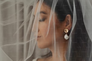 a woman wearing a veil and a pair of earrings